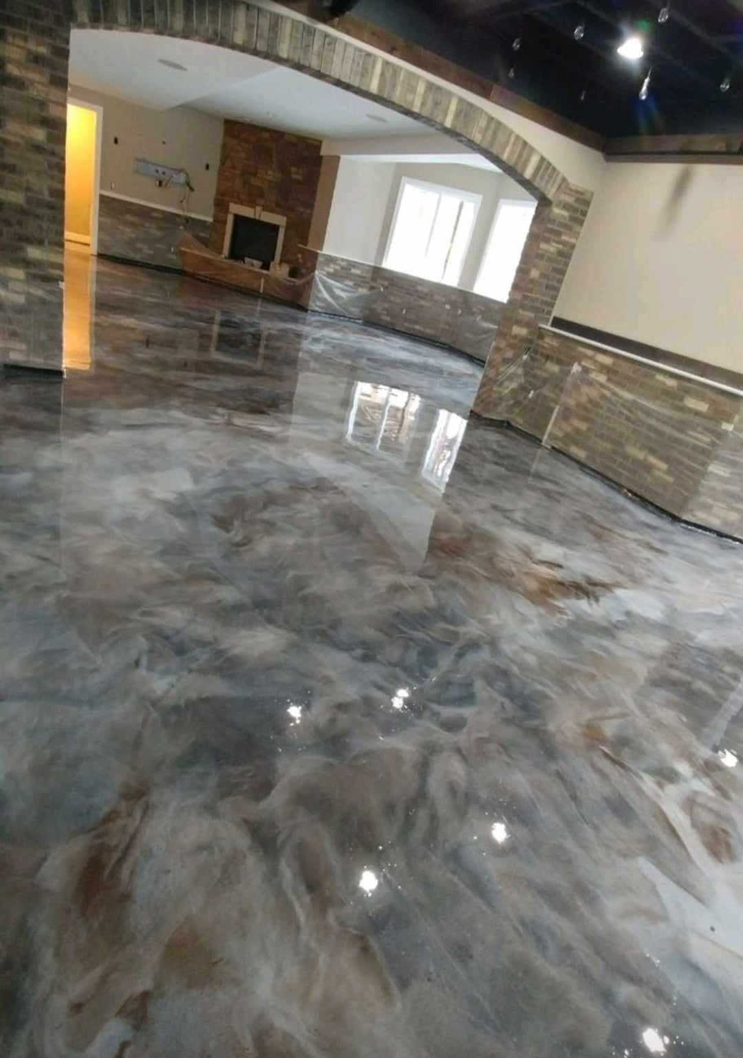 High-gloss decorative epoxy floor in a residential living area near a fireplace